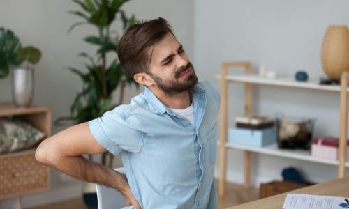 Man in pain at a desk from herniated disc