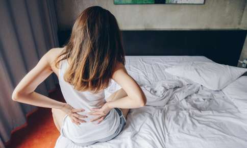 Woman waking up with back pain