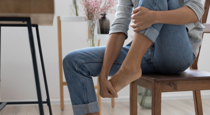 Woman holds her foot